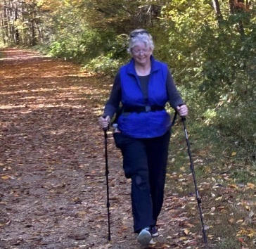 Ellen Kolb, a woman walking on a leaf-covered trail.